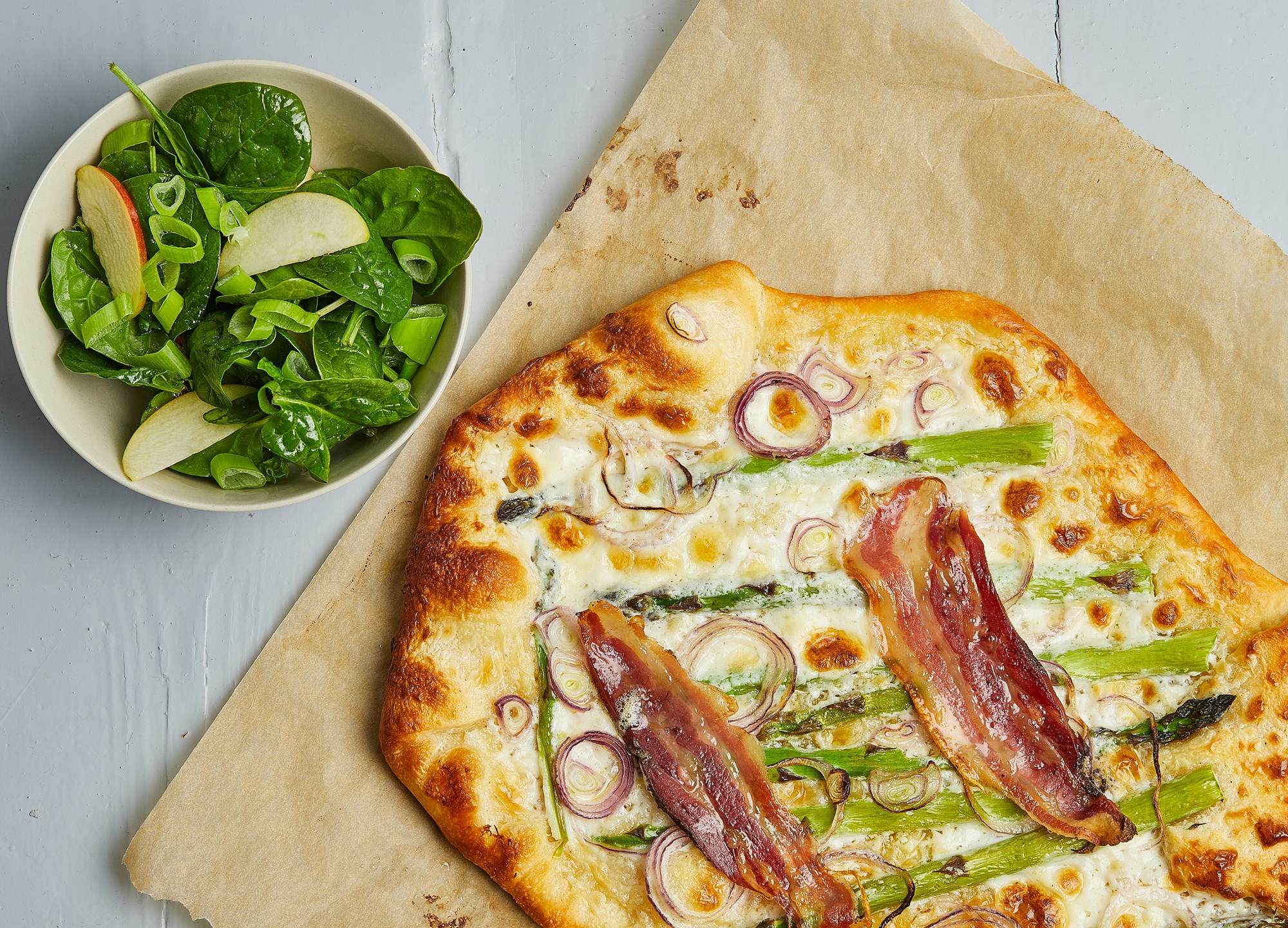 Forårspizza med grønne asparges, nye løg og bacon dertil spinatsalat