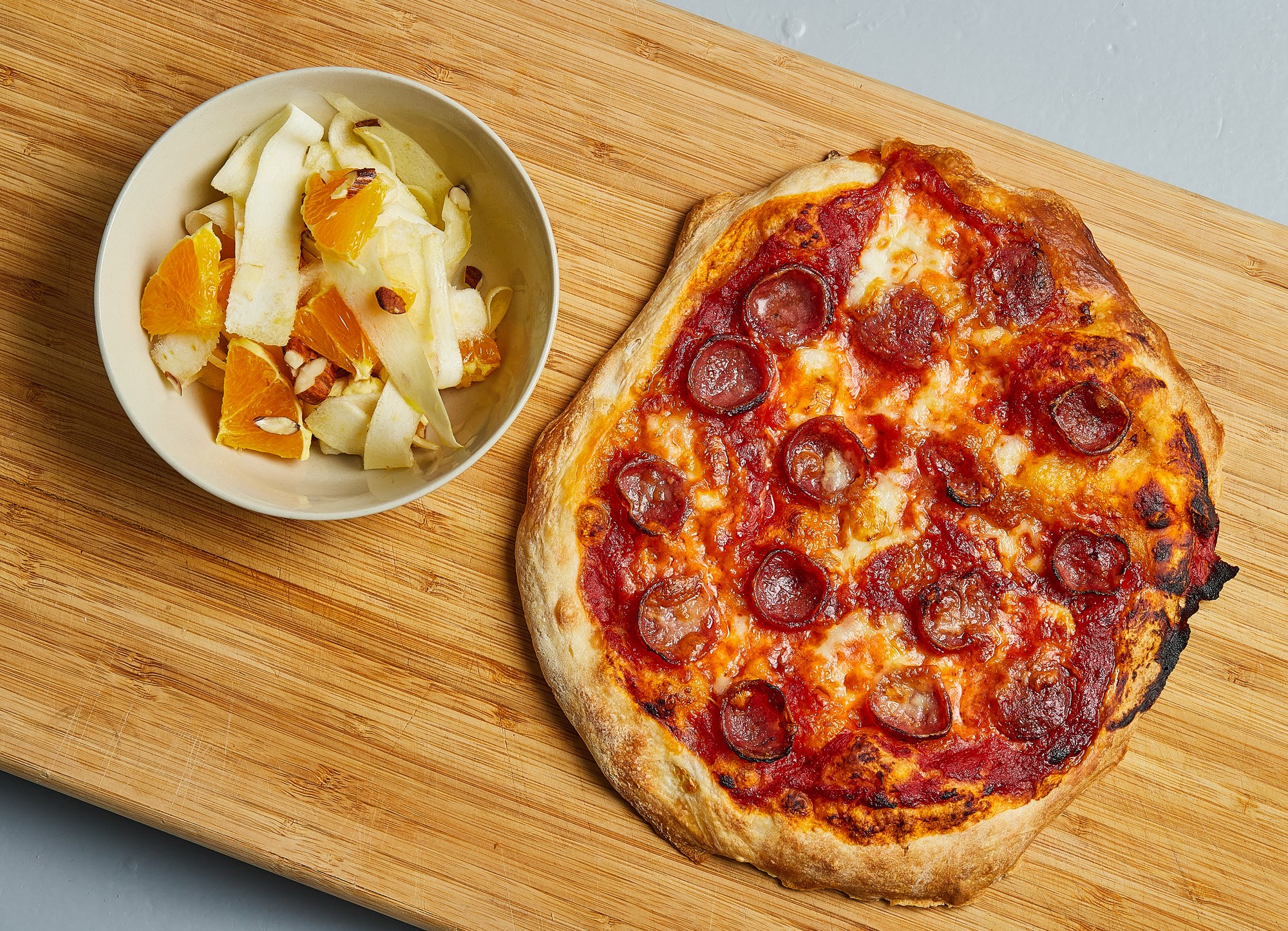 Pizza med mozzarella, pølse og syrlig råkostsalat